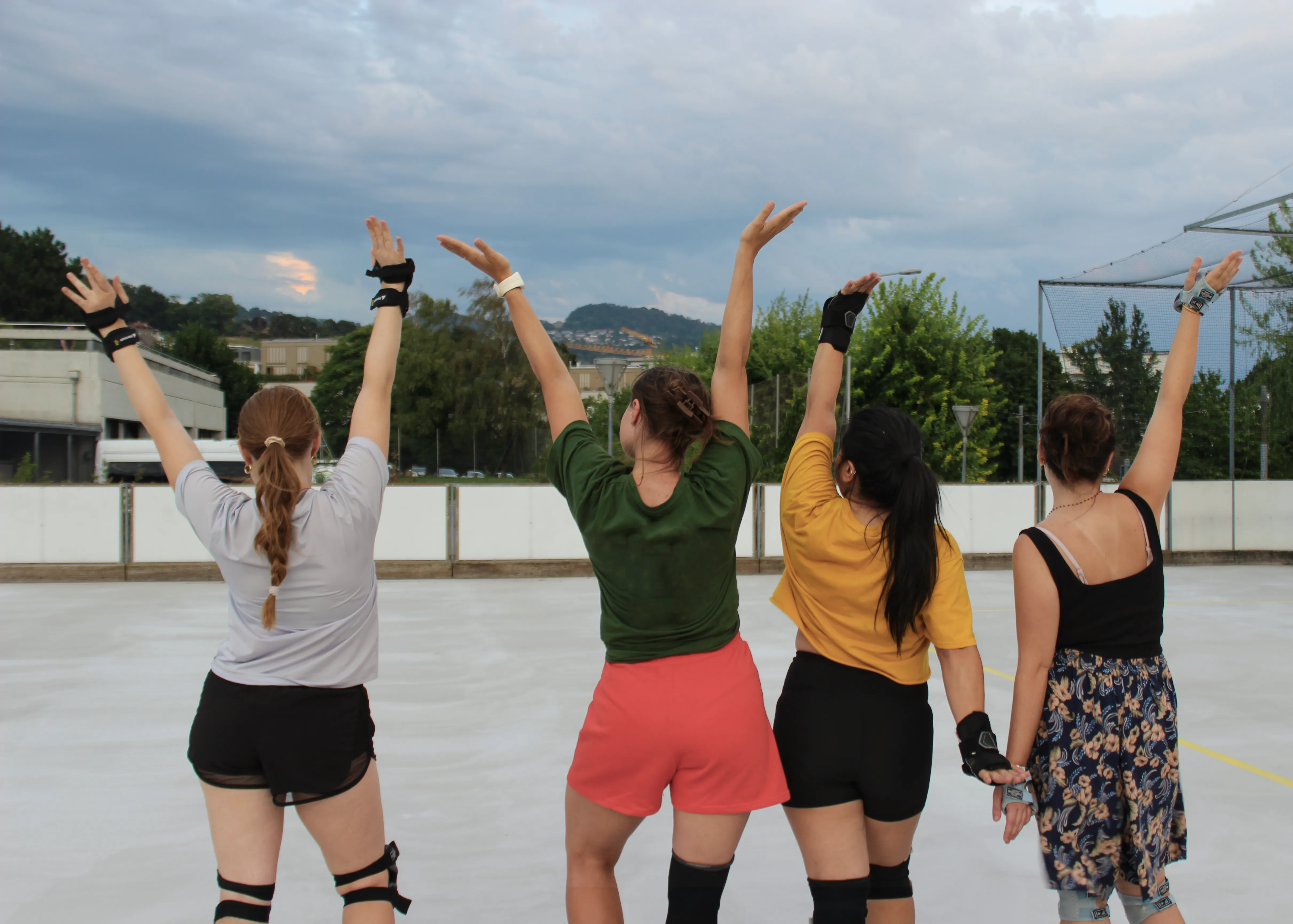 Quatre participantes adultes lèvent les bras ensemble pendant un entraînement
