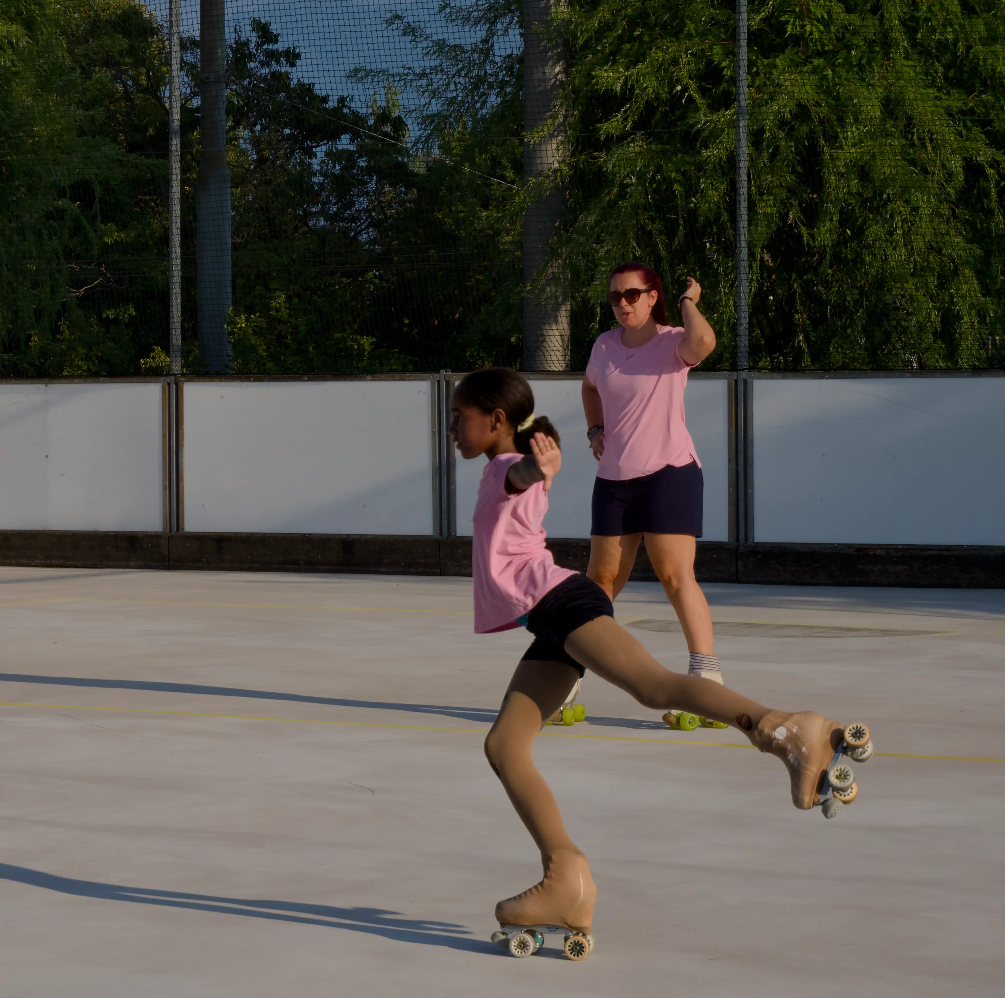 Une coach observe une jeune patineuse pendant un exercice