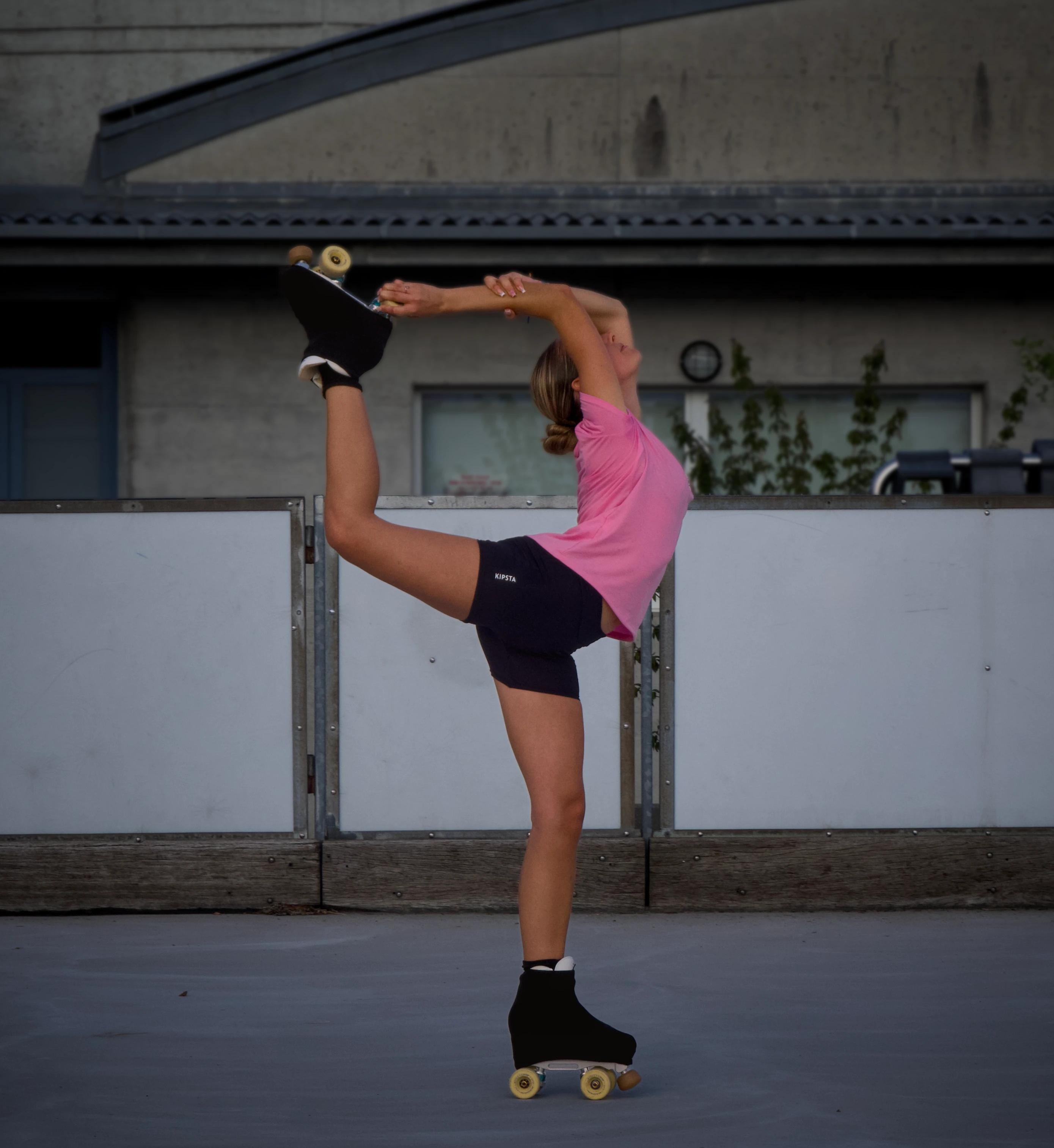Une patineuse réalise une figure en tenant son patin au-dessus de sa tête