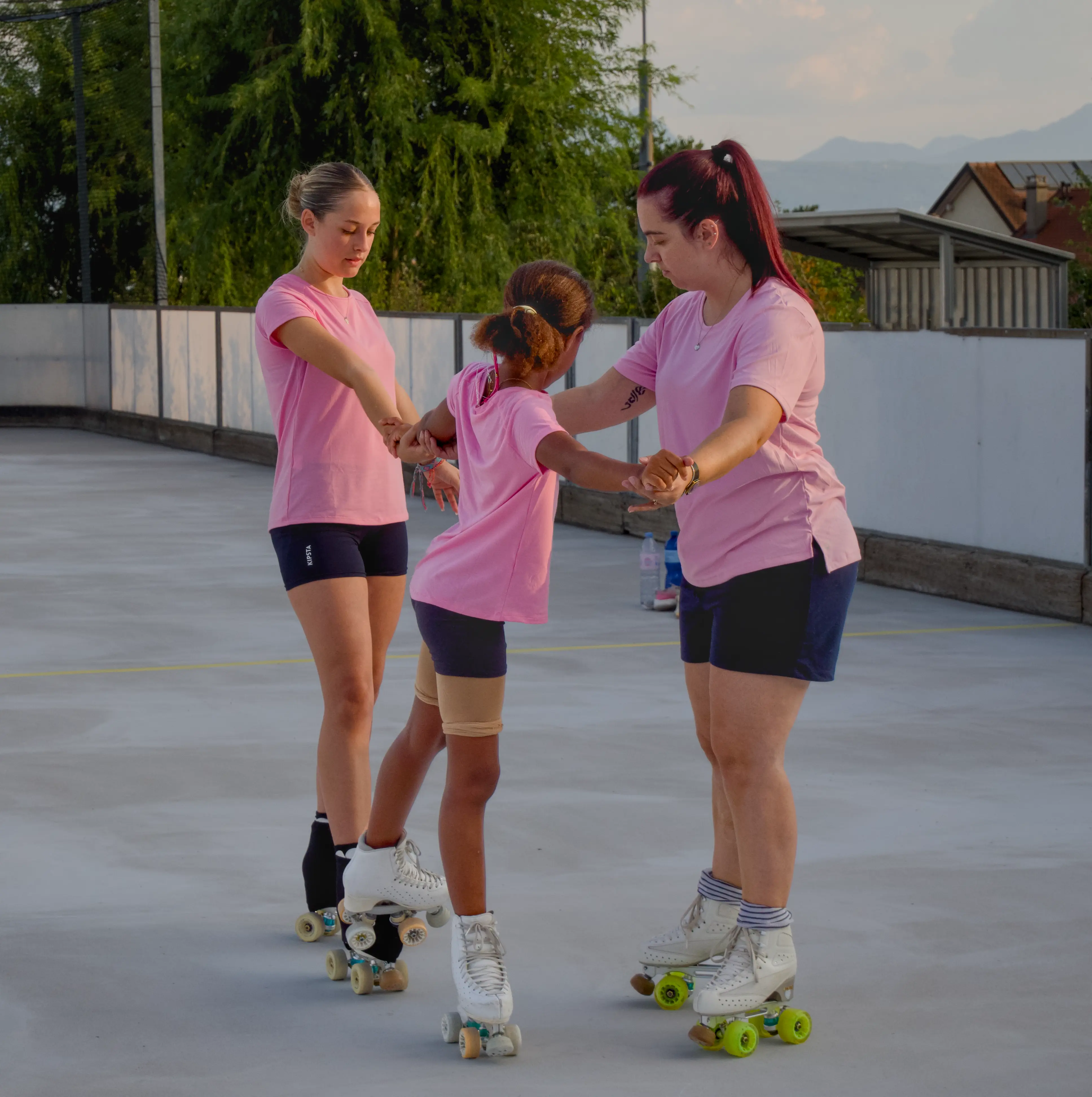 Deux coachs accompagnent une jeune patineuse pendant un exercice