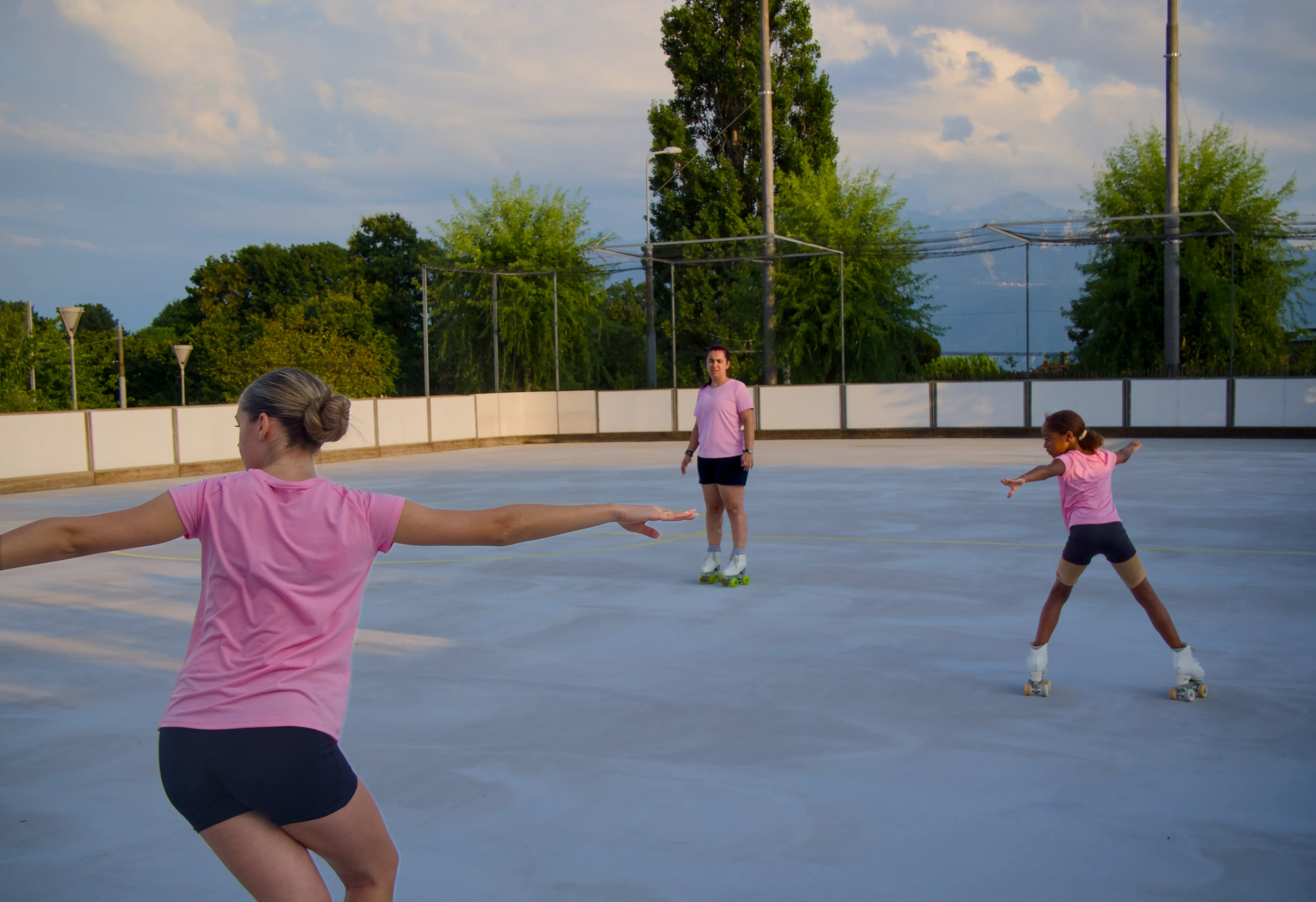 Trois patineuses s'entraînent ensemble sur une piste extérieure